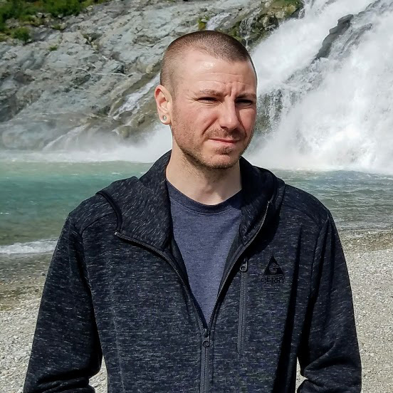 Chance Trahan in Juneau, Alaska visiting Mendenhall Glacier and taking a photo at Nugget Falls